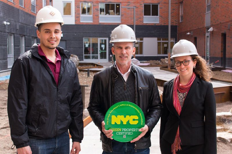 Group in construction hats holding a sign that reads, "NYC Green Project Certified"